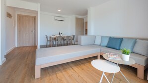 Una sala moderna con un sofá, una mesa de comedor y sillas.