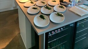 Une cuisine moderne dotée d’un îlot central, d’un four en acier inoxydable et d’une composition florale suspendue.