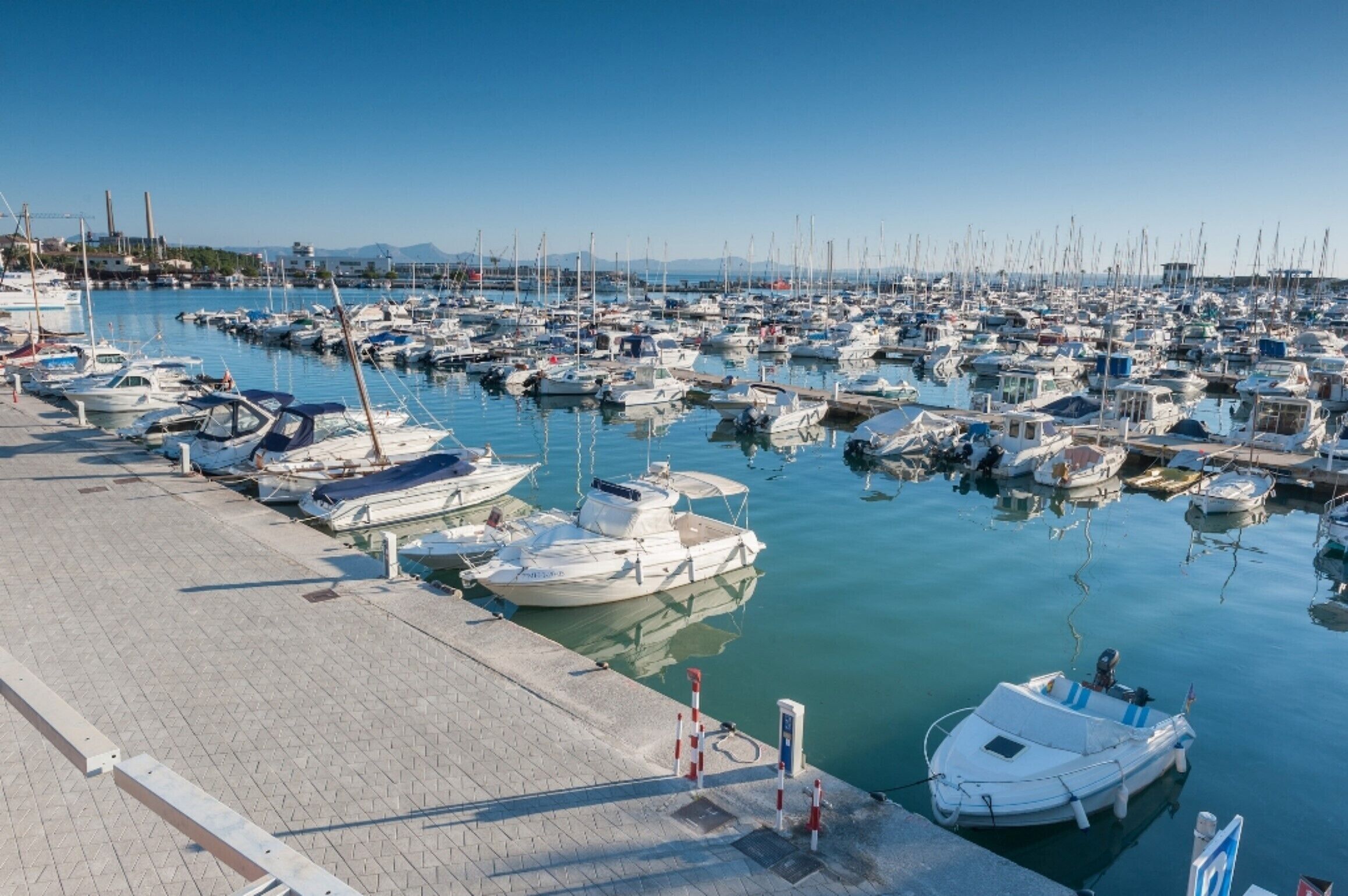 A marina with numerous boats docked along the waterfront.