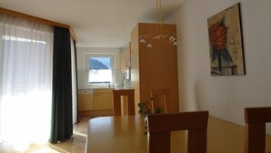 A dining area with a wooden table and chairs, a pendant light, and a painting on the wall. - Pepi's vacation apartments including summer card with   17 services (Jerzens)