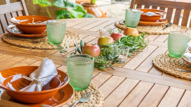 A wooden table set with green glassware, orange plates, and fresh fruits. - CA NA ROSA (DE SELVA) - Apartment with private pool and garden near the mountains. Free Wi (Selva)