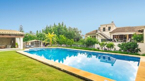 A rectangular swimming pool with a tiled deck, surrounded by a well-maintained lawn and various plants. - CA NA ROSA (DE SELVA) - Apartment with private pool and garden near the mountains. Free Wi (Selva)