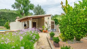 A house with a stone pathway leading to a covered patio area. - CA NA ROSA (DE SELVA) - Apartment with private pool and garden near the mountains. Free Wi (Selva)