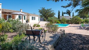 A house with a swimming pool, a garden with a wheelbarrow, and a solar panel. - CA NA MENUDA - Cosy country house with private pool in quiet surroundings. Free WiFi (Sencelles)