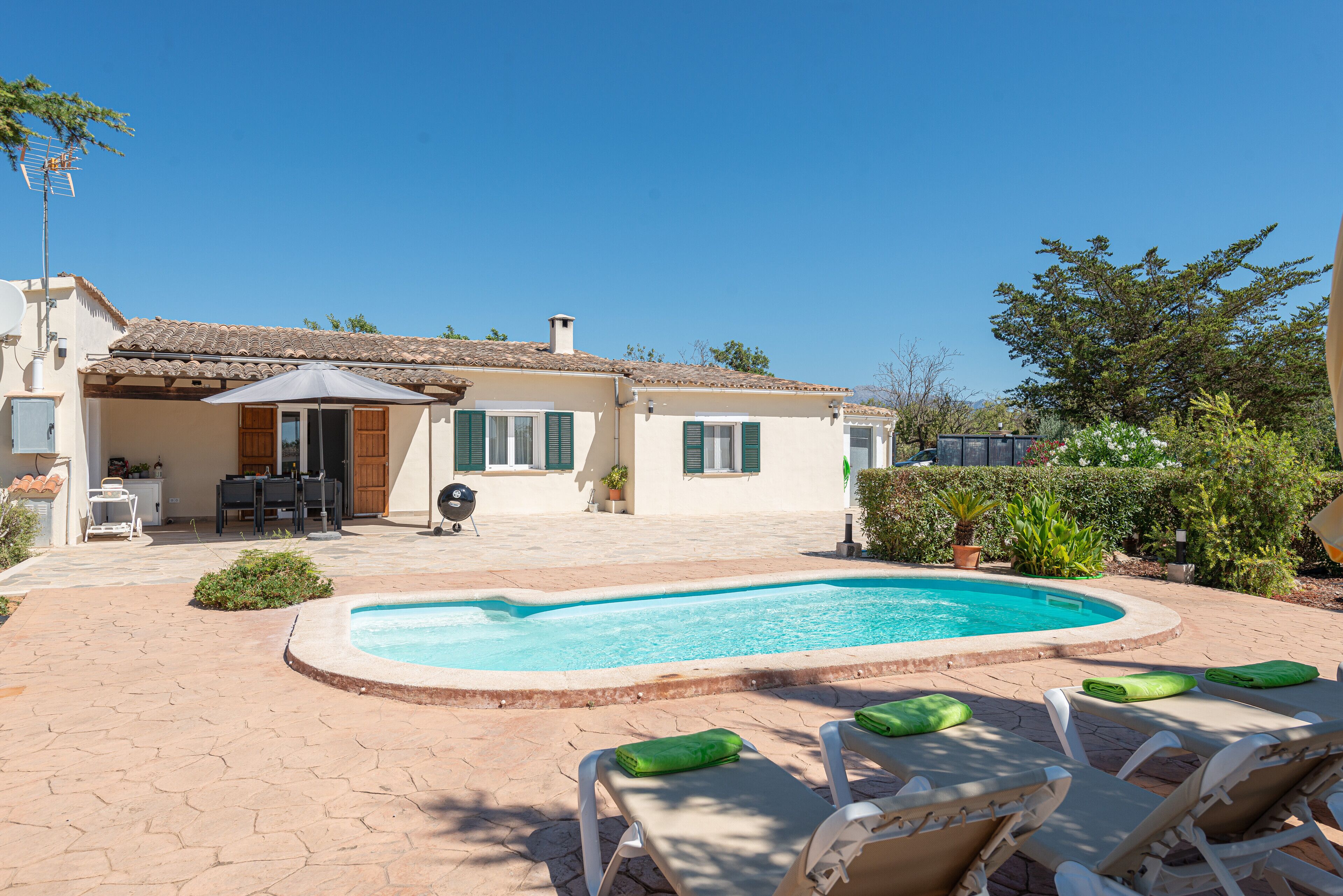 A house with a swimming pool, outdoor furniture, and a patio area.
