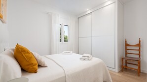 A bedroom with a bed, a chair, a window, and a wardrobe. - CA NA MENUDA - Cosy country house with private pool in quiet surroundings. Free WiFi (Sencelles)