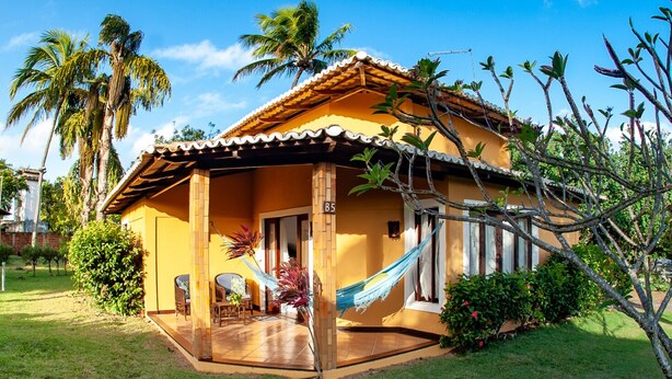 Ein kleines, eingeschossiges Haus mit Ziegeldach und Veranda.