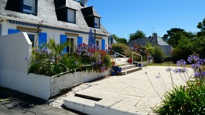 A row of white houses with blue shutters and a clear blue sky.