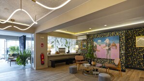 Un hall d’entrée moderne avec un plancher en bois, un espace salon et un grand tableau accroché au mur.
