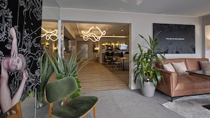 Un intérieur moderne avec un canapé, des fauteuils et des plantes en pot.