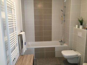 Een bad, handdoeken, zeep, toiletpapier