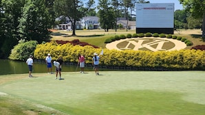 A golf course with a large scoreboard, neatly trimmed hedges, and a pond. - Kingsmill Condo on Golf Course 9th Fairway! Local owner (Williamsburg)
