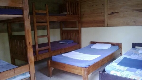 A dormitory room with bunk beds and a single bed. - Posada Las Marias (San Agustin Lanquin)