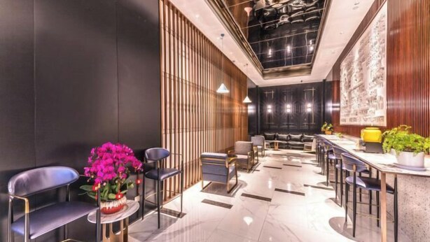 A modern hotel lobby with a seating area, a reception desk, and a decorative wall. - Jinjiang Inn (Wujiang Zhongshan North Road Pedestrian Street) (Suzhou)