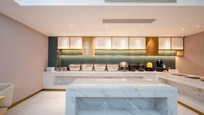 A modern kitchen with marble countertops, a central island, and a green backsplash. - Jinjiang Inn (Wujiang Zhongshan North Road Pedestrian Street) (Suzhou)