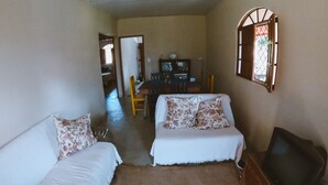 A room with two beds, a television, and a dining area with chairs and a table. - Casa de Campo Rosalinda (Sao Manuel de Carangola)