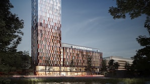 A modern hotel with a unique architectural design featuring a tall, rectangular structure with a glass facade and a lower section with a patterned facade.