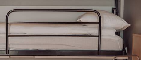 A bunk bed with a metal frame and white bedding.