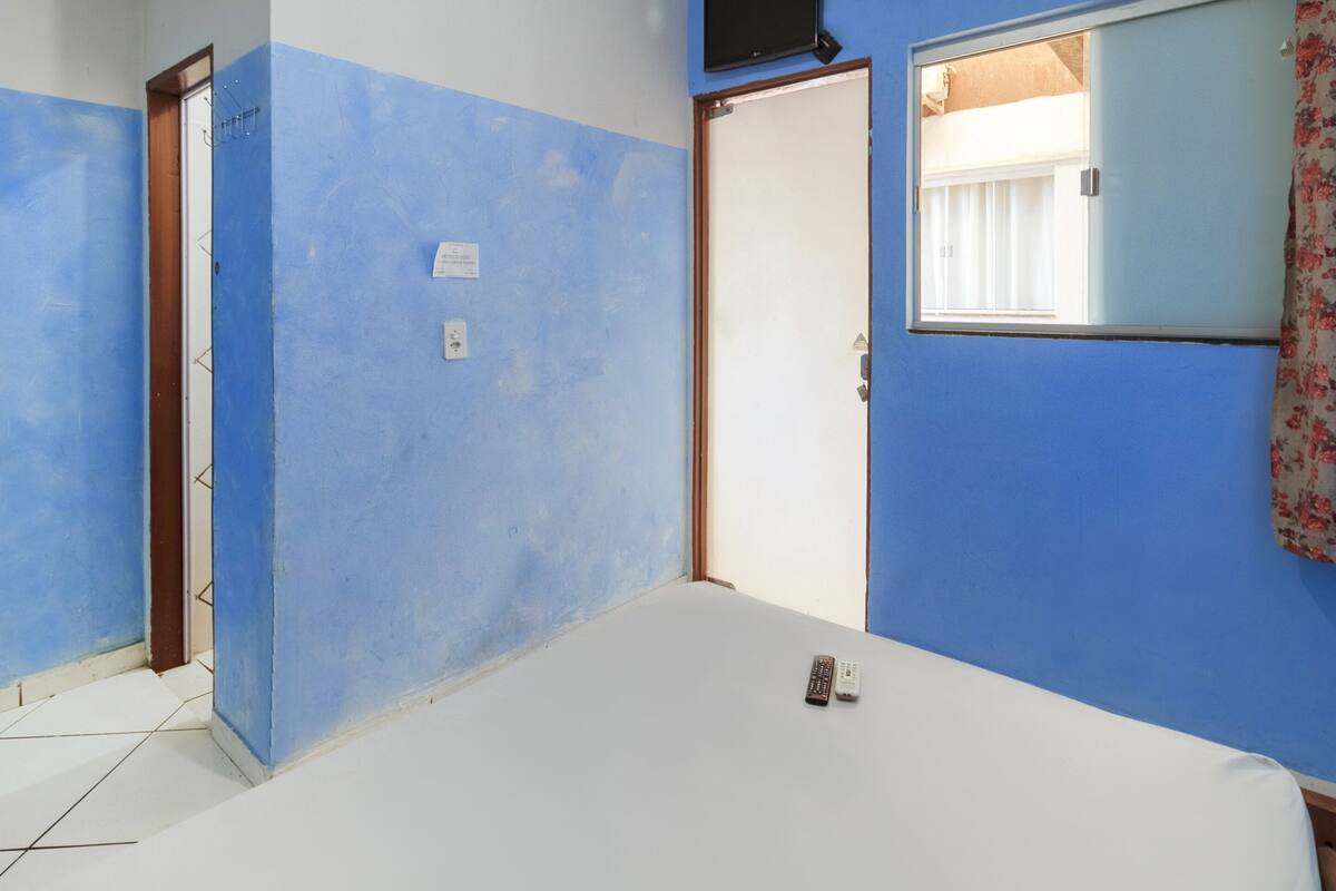 Ein Zimmer mit einem Bett, einer Tür und einem Fenster.