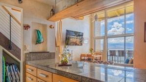 Una cocina moderna con encimeras de granito, armarios de madera y un amplio ventanal con vistas al exterior.