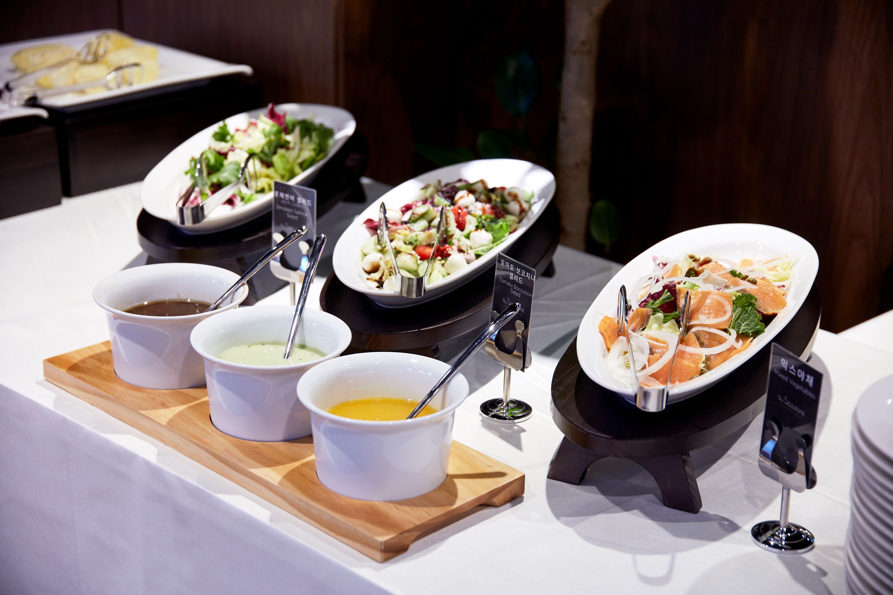 A buffet with various dishes and condiments.