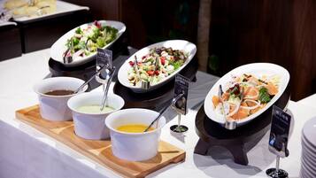 A buffet with various dishes and condiments.