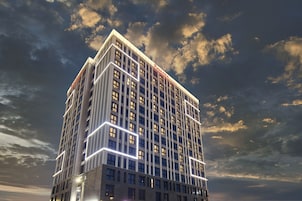 A tall, modern building with a grid of windows and a prominent name at the top.