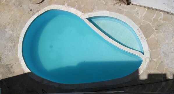 Enjoy a refreshing swim in the resort's unique, curved pool surrounded by a stone wall.