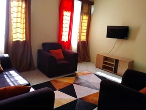 Relax in this stylish living room with a sofa, armchair, and flat-screen TV.