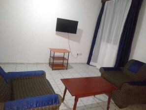 Relax in this cozy space with a flat-screen TV, two sofas, and a small table.