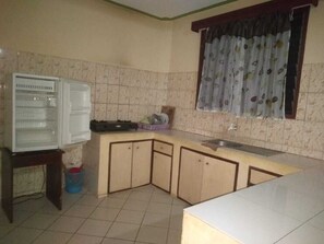 Compact kitchen with a refrigerator, sink, and window overlooking a view.