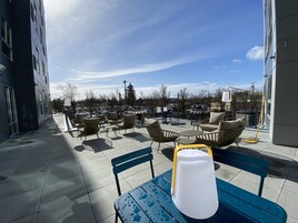 A rooftop patio with outdoor seating and a view of the cityscape.