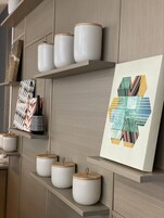 A modern interior with shelves displaying decorative items and a framed artwork.