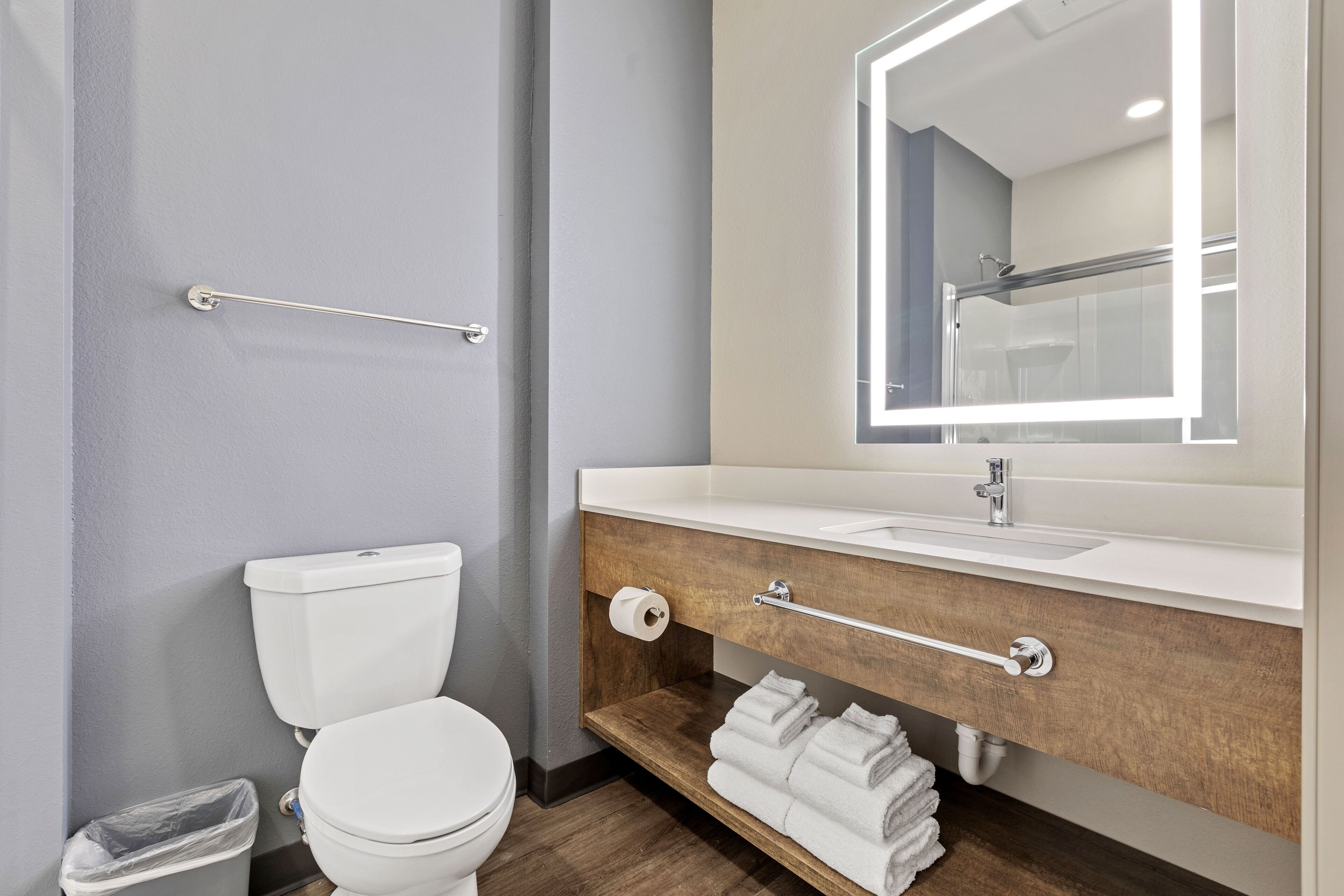 A modern bathroom with a toilet, sink, and mirror.