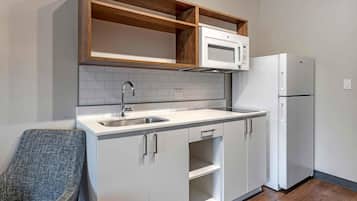 Una cocina compacta con microondas, refrigerador y pileta doble.