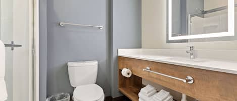 Een moderne badkamer met toilet, wastafel en spiegel.