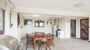 Un comedor con mesa y sillas de madera, una lavadora y un letrero de 'No Estacionar'.