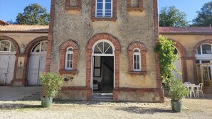 A two-story building with a central entrance, arched windows, and a tiled roof. - Gîte Rohan - Château du Parc Soubise (Mouchamps)