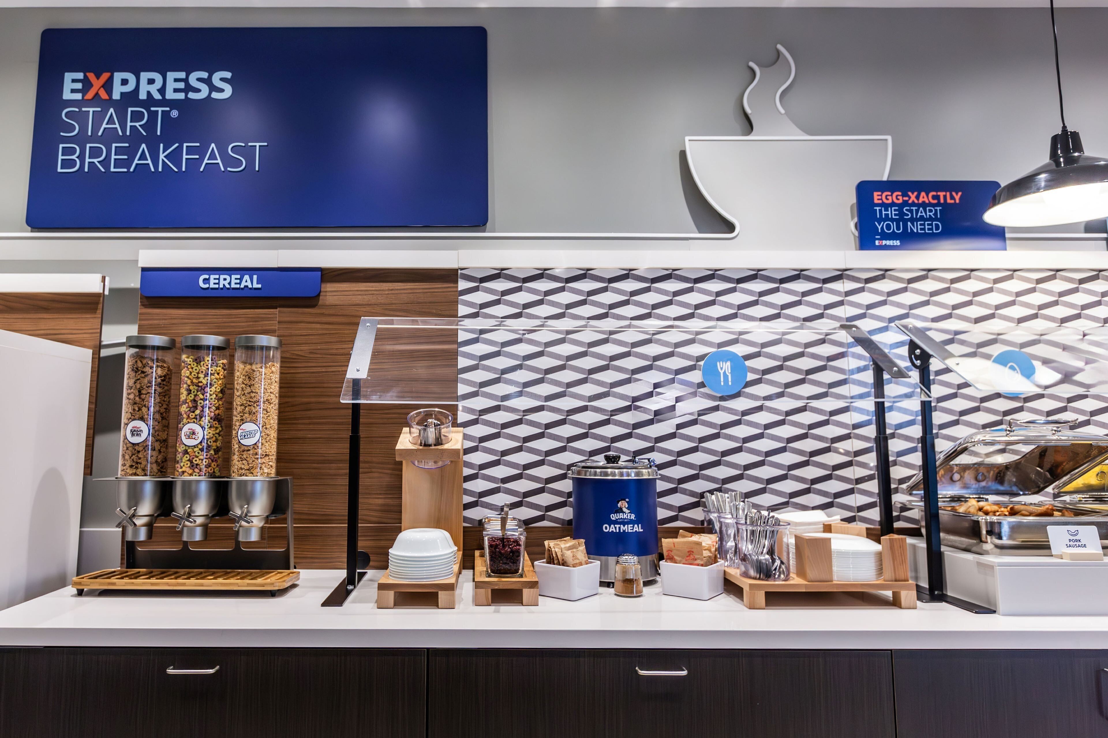 Un buffet de petit-déjeuner avec des distributeurs étiquetés pour les céréales, le gruau et autres produits.