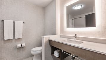 Een moderne badkamer met toilet, wastafel en spiegel.