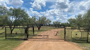 A gated entrance with a metal gate and a number "775" on it.