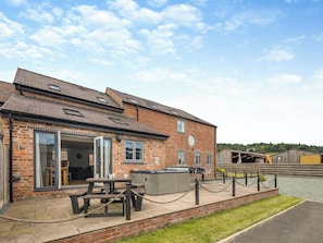 A brick building with a patio area, a table, and a barbecue grill. - 3 bedroom accommodation in Trevor, near Llangollen (Trevor, near Llangollen)