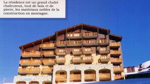 A multi-story chalet with wooden balconies and stone construction. - BELLE PLAGNE 2 rooms, sleeps 5-6, ski-in/ski-out + covered parking included (LA PLAGNE)