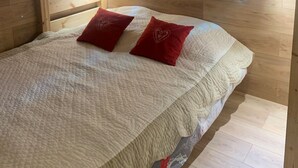 A bunk bed with a wooden headboard, two red pillows with heart designs, and two wall-mounted reading lights. - BELLE PLAGNE 2 rooms, sleeps 5-6, ski-in/ski-out + covered parking included (LA PLAGNE)