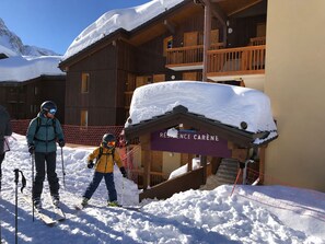 Un bâtiment en bois avec une enseigne indiquant « RÉSIDENCE CARÈNE » et un toit recouvert de neige.