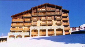 Ein mehrstöckiges Chalet mit Holzbalkonen und Steinbauweise.