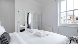 A hotel room with a bed, a wardrobe, a window, and a view of the outside. - The Cadogan Suite next to Sloane Square (London)