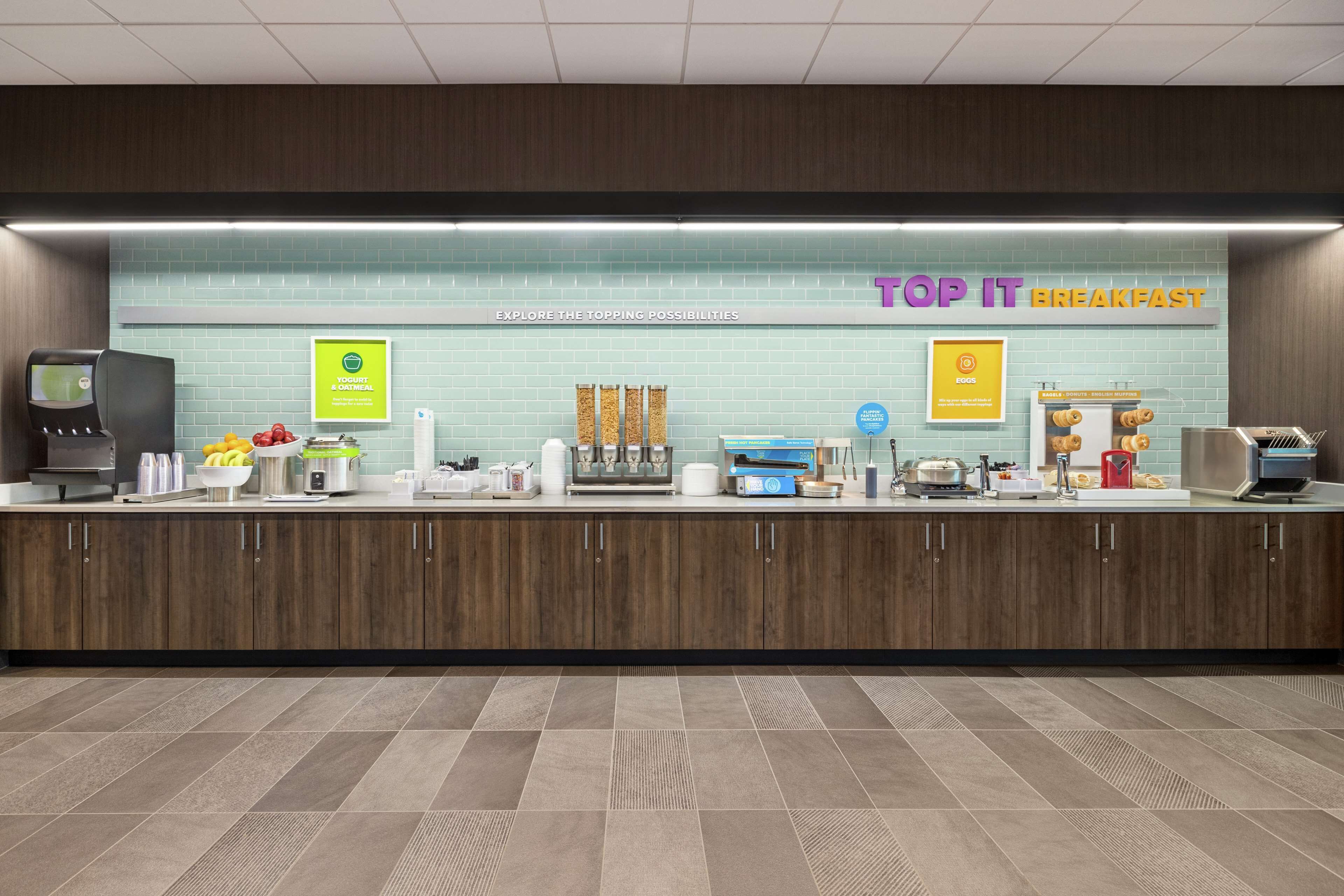 Una barra de desayuno con un letrero que dice "TOP IT BREAKFAST" y varios alimentos a la vista.