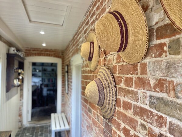 A brick wall with several straw hats hanging on it. - Picturesque cottage for two in the Kent countryside - Moat Farm Cottage (Ash)