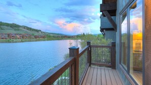 Eine Holzterrasse mit Blick auf einen Fluss und Häuser im Hintergrund.